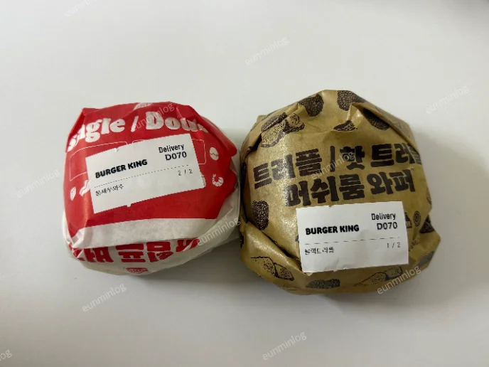 포장된 통새우와퍼주니어와 블랙 트러플치즈 버거의 크기 비교